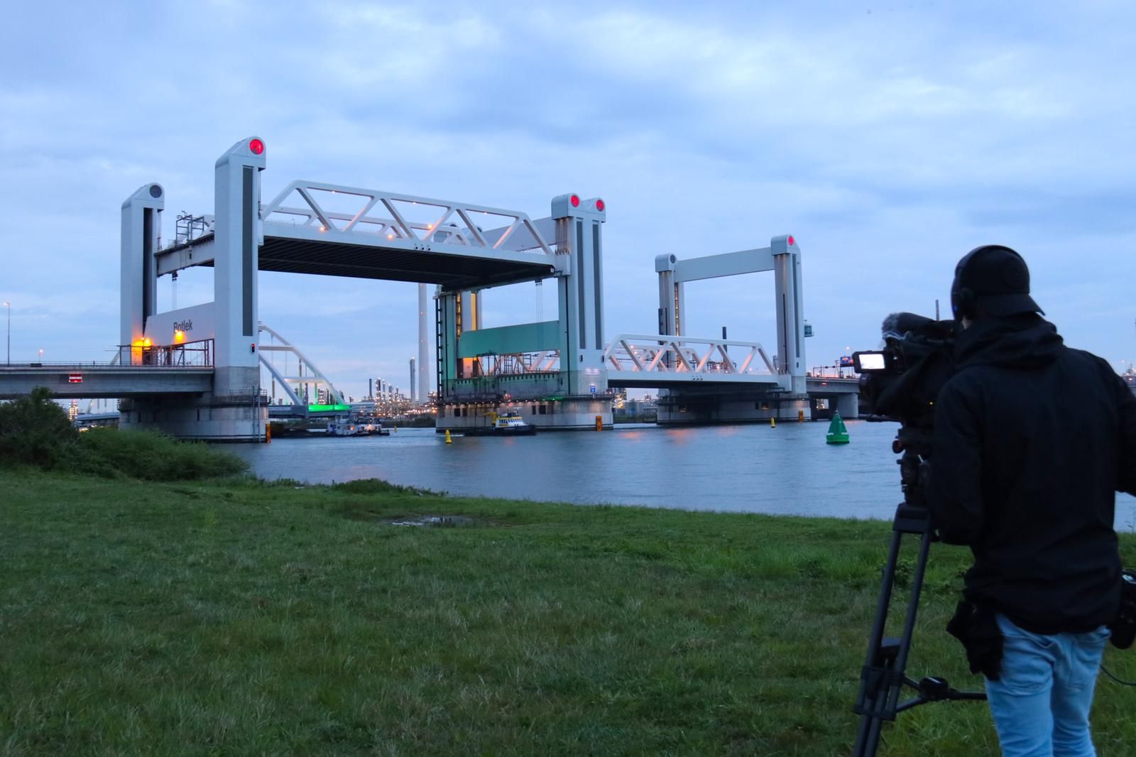 Een camera operator aan de kade vlak voor de passage van de Botlekbrug